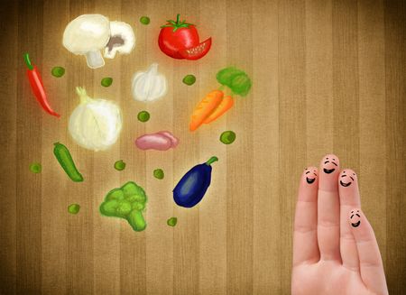 Happy smiley face fingers cheerfully looking at illustration of colorful healthy vegetables