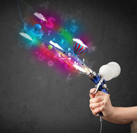 Worker with airbrush and colorful abstract clouds and balloons concept