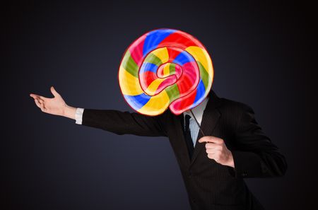 Businessman holding a colorful striped lollipop in front of his head