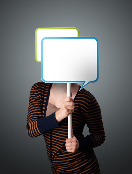 Young lady standing and holding an empty speech bubble in front of her head