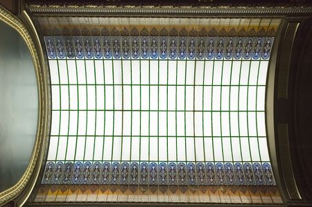 Skylight with stained glass above mural with gilded frame in state capitol building