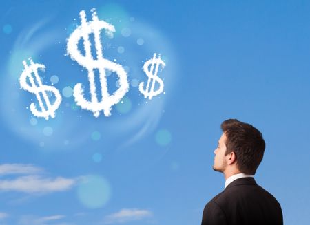 Businessman pointing at dollar sign clouds on blue sky concept