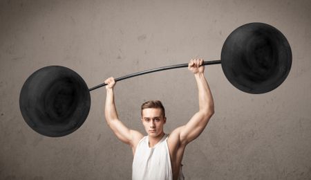 Strong muscular man lifting weights