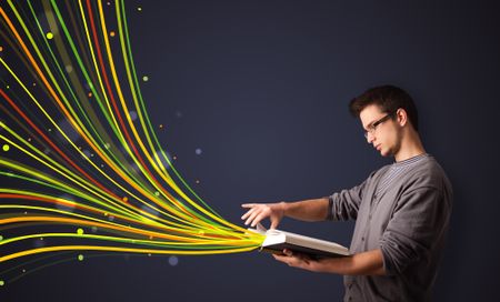 Young man reading a book while colorful lines are coming out of the book