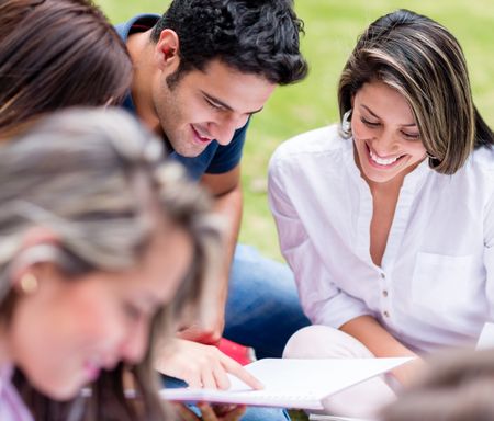 Group of students outdoors studying together and smiling 