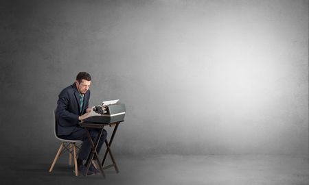 Man working hard on a typewriter in an empty space