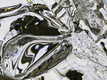 Winter abstract: Ice reflecting and distorting ambient light outdoors (shallow depth of field)