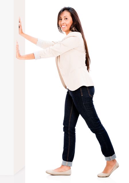 Happy woman pushing the wall - isolated over white background