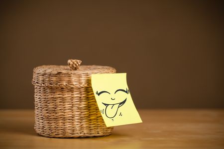 Drawn smiling face on a post-it note sticked on a jewelry box