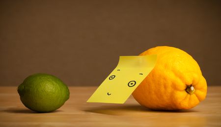 Lemon with sticky post-it note watching at lime