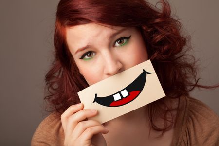 Happy pretty woman holding card with funny smiley on gradient background