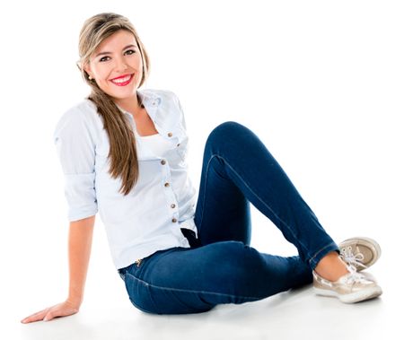 Casual woman sitting on the floor smiling - isolated over a white background 