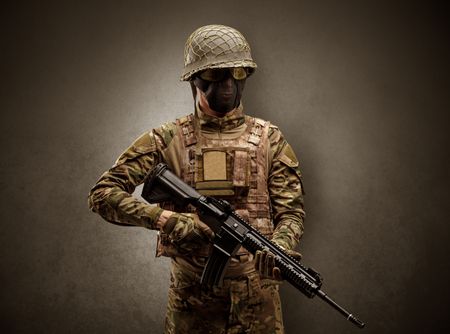Soldier agent in a dark room with arms on his hand and gas mask