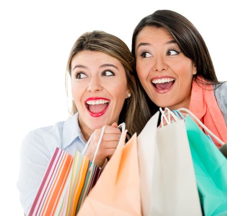 Surprised shopping women holding bags - isolated over a white background