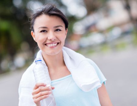 Happy gym woman holding a bottle of water