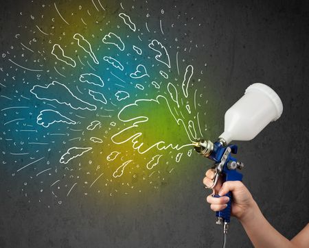 Worker with airbrush gun paints colorful lines and splashes concept