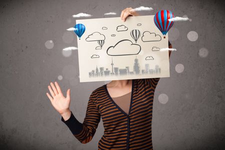 Woman holding a cardboard in front of her head with cityscape and ballons drawing