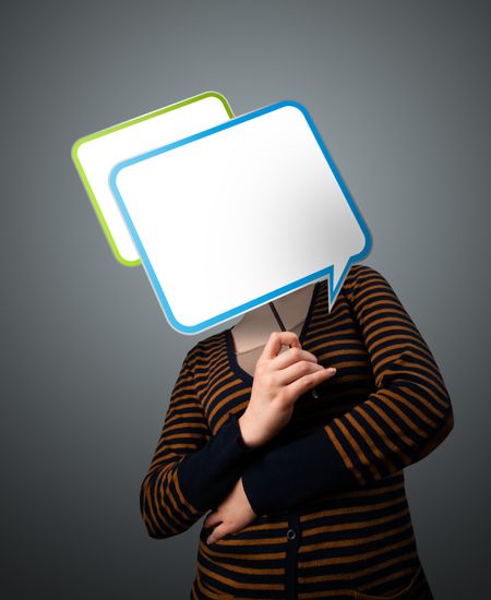 Young lady standing and holding an empty speech bubble in front of her head