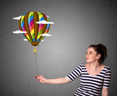 Young woman holding a balloon drawing with clouds