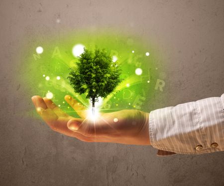 Young woman holding a glowing tree in her hand