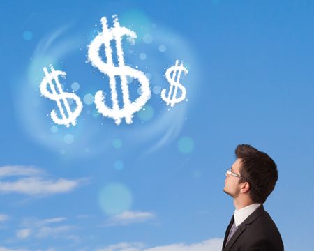 Businessman pointing at dollar sign clouds on blue sky concept
