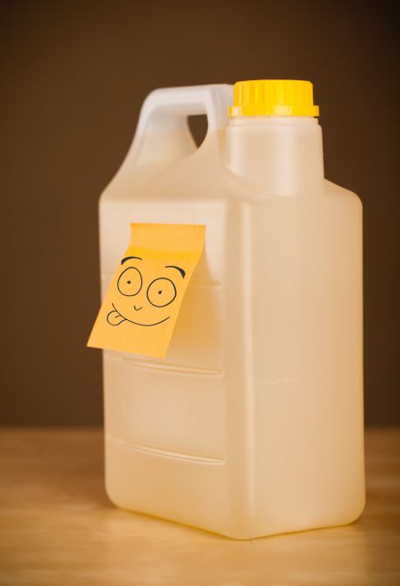 Drawn smiley face on a post-it note sticked on a gallon