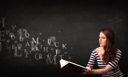 Young lady reading a book with alphabet letters coming out of the book