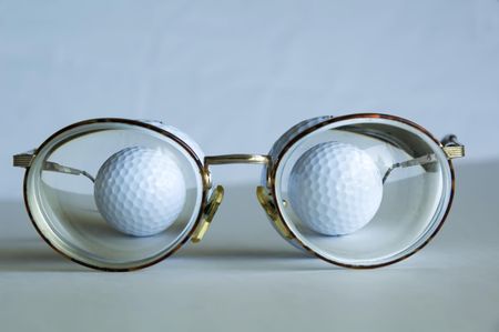 Two golf balls behind thick lenses of eyeglasses