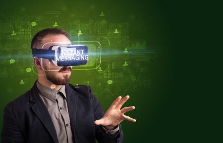 Businessman looking through Virtual Reality glasses with INSTANT MESSAGING inscription, social networking concept