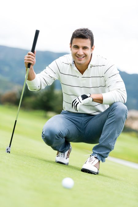 Male golf player at the course holding a club