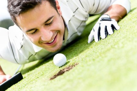Golf player cheating by blowing the ball into a hole 