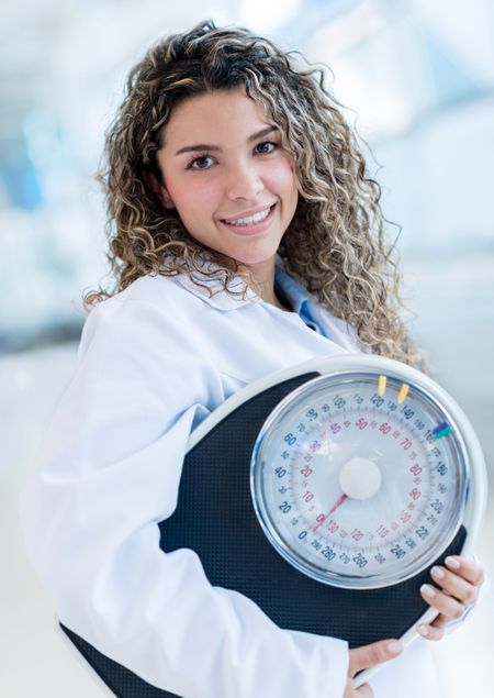 Female nutritionist with a weight scale at the hospital 