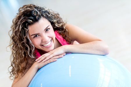 Woman with a Pilates ball at the gym smiling 