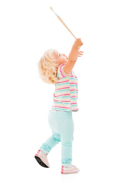 Excited little girl with a paint brush - isolated over white background