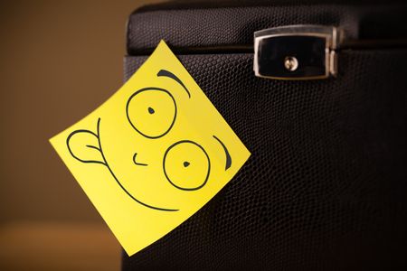 Drawn smiley face on a post-it note sticked on a jewelry box