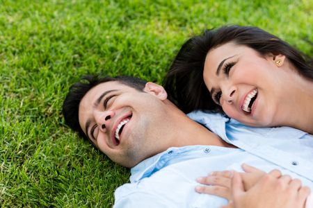 Beautiful couple in love lying on the floor outdoors 