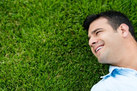 Man portrait lying on the grass outdoors 