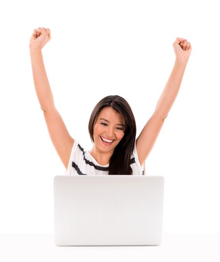 Happy woman winning something online with arms up - isolated over white 