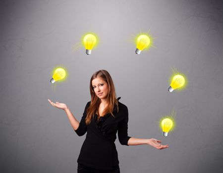 beautiful young lady standing and juggling with light bulbs