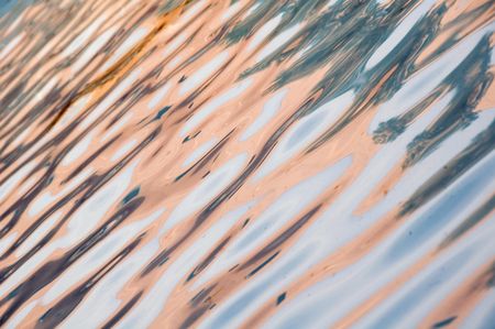 Rippled reflections of light-colored wall in an outdoor pool