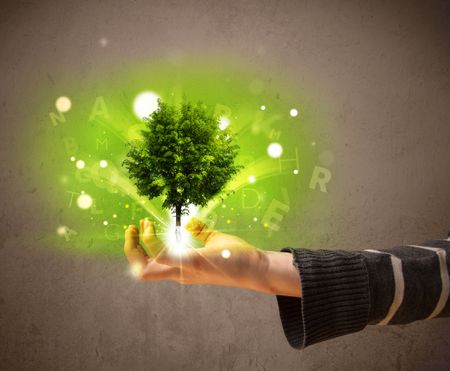Young woman holding a glowing tree in her hand