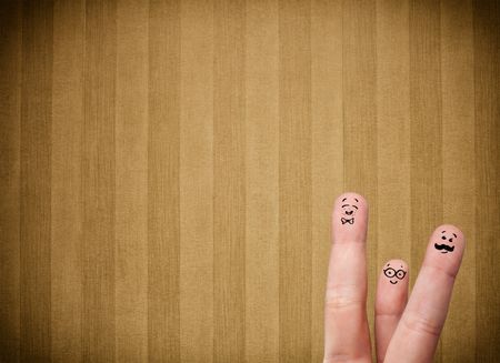 Happy finger smileys faces on hand with vintage stripe wallpaper background