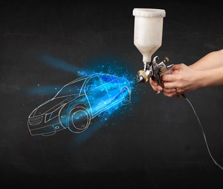 Worker with airbrush gun painting hand drawn white car lines