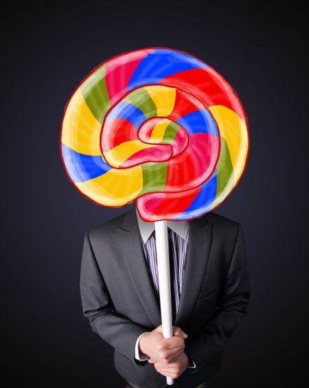 Businessman holding a colorful striped lollipop in front of his head