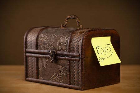 Drawn smiley face on a post-it note sticked on a jewelry box