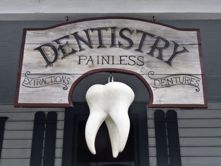 Vintage sign with giant tooth hanging in front of dentist's office