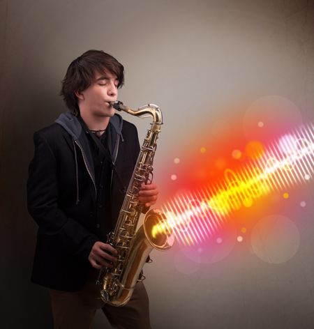 Attractive young man playing on saxophone with colorful sound waves