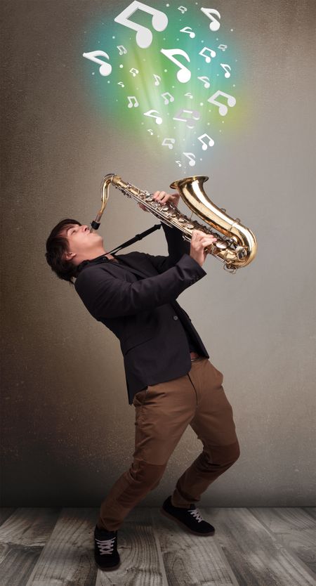 Attractive young musician playing on saxophone while musical notes exploding