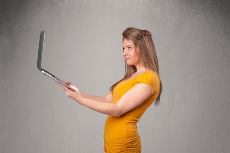 Pretty young woman holding modern laptot