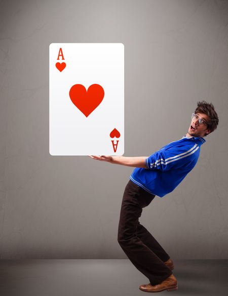 Attractive young man holding a red heart ace